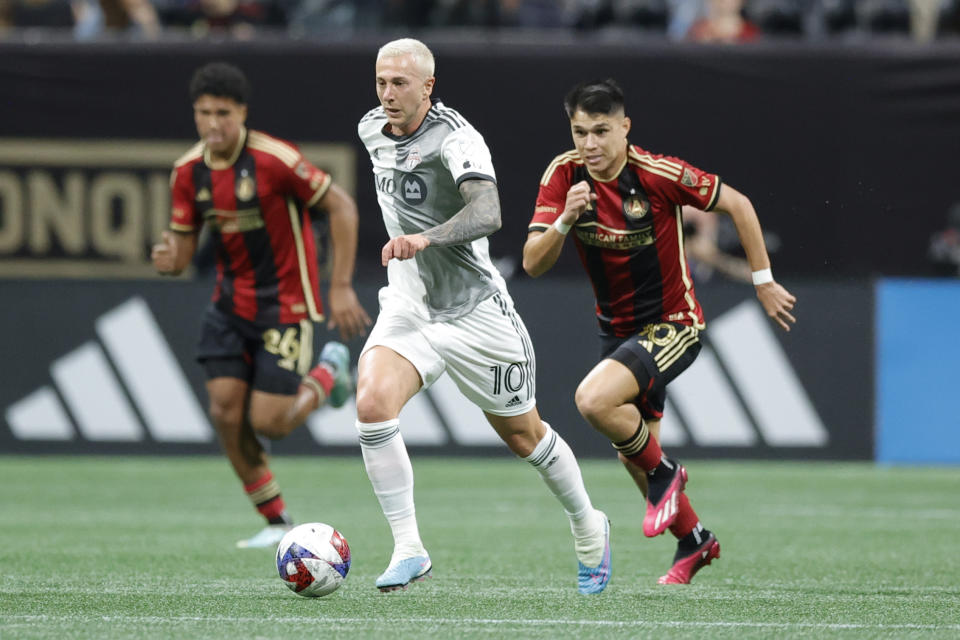 Toronto FC forward Federico Bernardeschi, center, drives past Atlanta United defender Caleb Wiley, left and Atlanta United midfielder Luiz Araújo, right, during the first half of an MLS soccer match, Saturday, March 4, 2023, in Atlanta. (AP Photo/Alex Slitz)