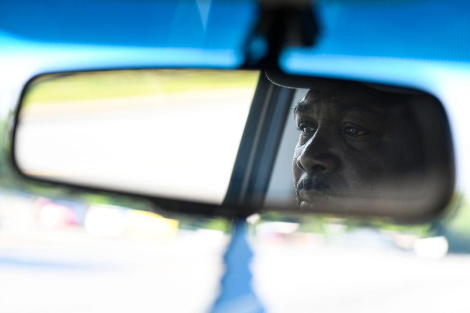 Henry Thomas is reflected in the rearview mirror as he drives to the Saluda Dam Road Department of Motor Vehicles office before his drivers license test on Thursday, May 25, 2023.