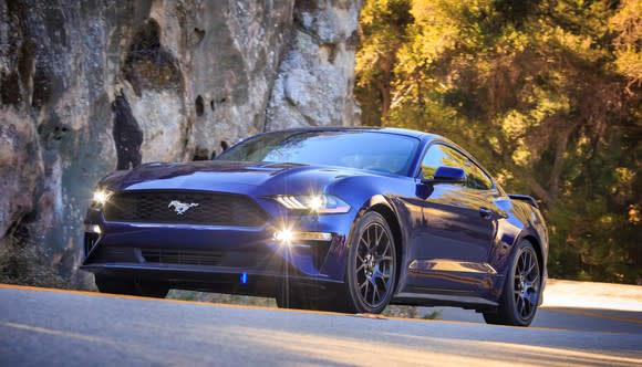 A dark blue 2018 Ford Mustang fastback on a mountain road.