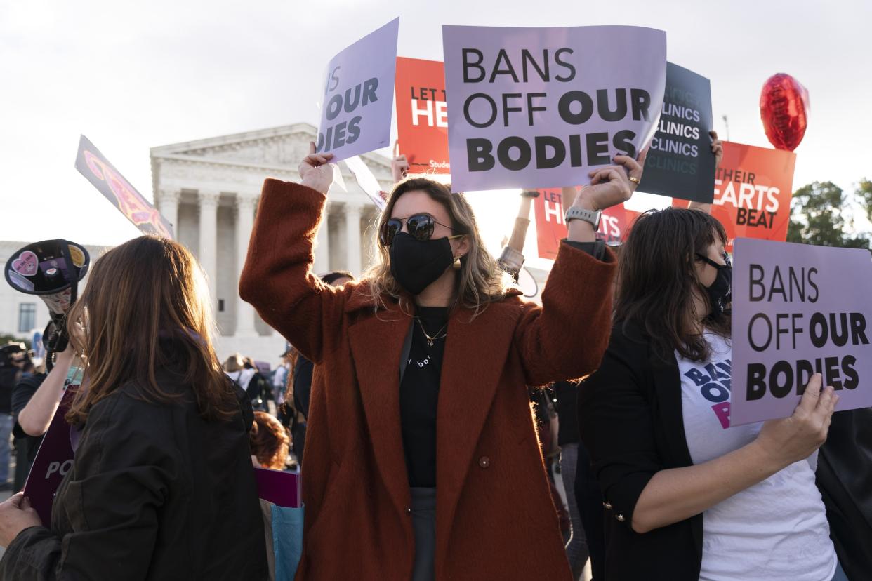 Emily Halvorson, center, of Washington, with Planned Parenthood, joins groups of abortion-rights and anti-abortion activists as they rally outside the Supreme Court, Monday, Nov. 1, 2021, as arguments are set to begin about abortion by the court, on Capitol Hill in Washington. (AP Photo/Jacquelyn Martin)