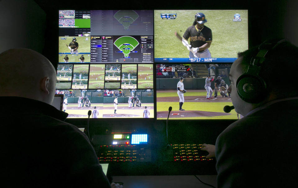 Two technicians work in a booth during a preview of Major League Baseball's Replay Operations Center, in New York, Wednesday, March 26, 2014. Less than a week before most teams open, MLB is working on the unveiling of its new instant replay system, which it hopes will vastly reduce incorrect calls by umpires. (AP Photo/Richard Drew)