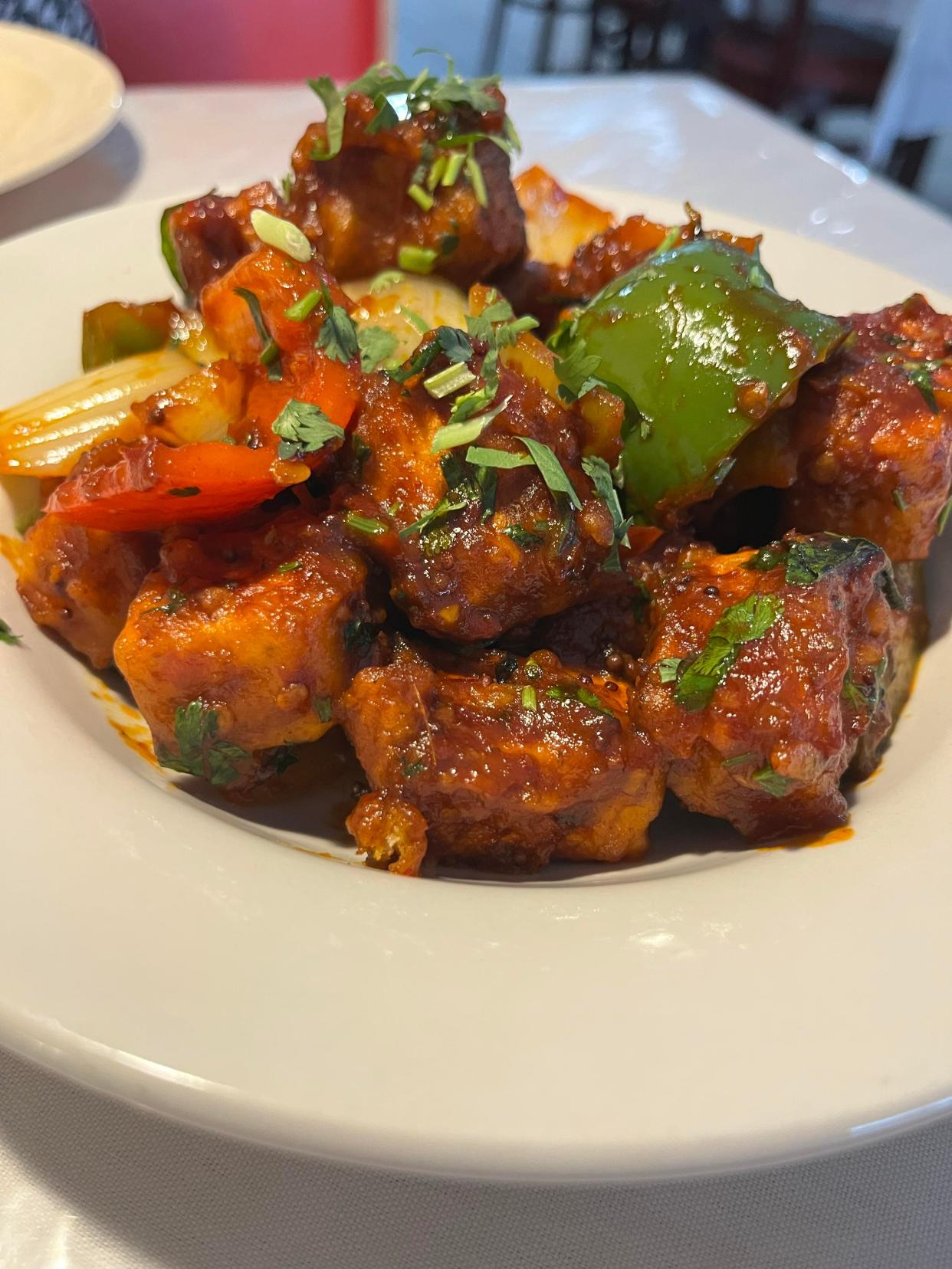 Chili paneer is a gluten-free, vegetarian appetizer made of batter-fried Indian cheese tossed in sweet and spicy chili sauce, topped with onions and bell peppers.