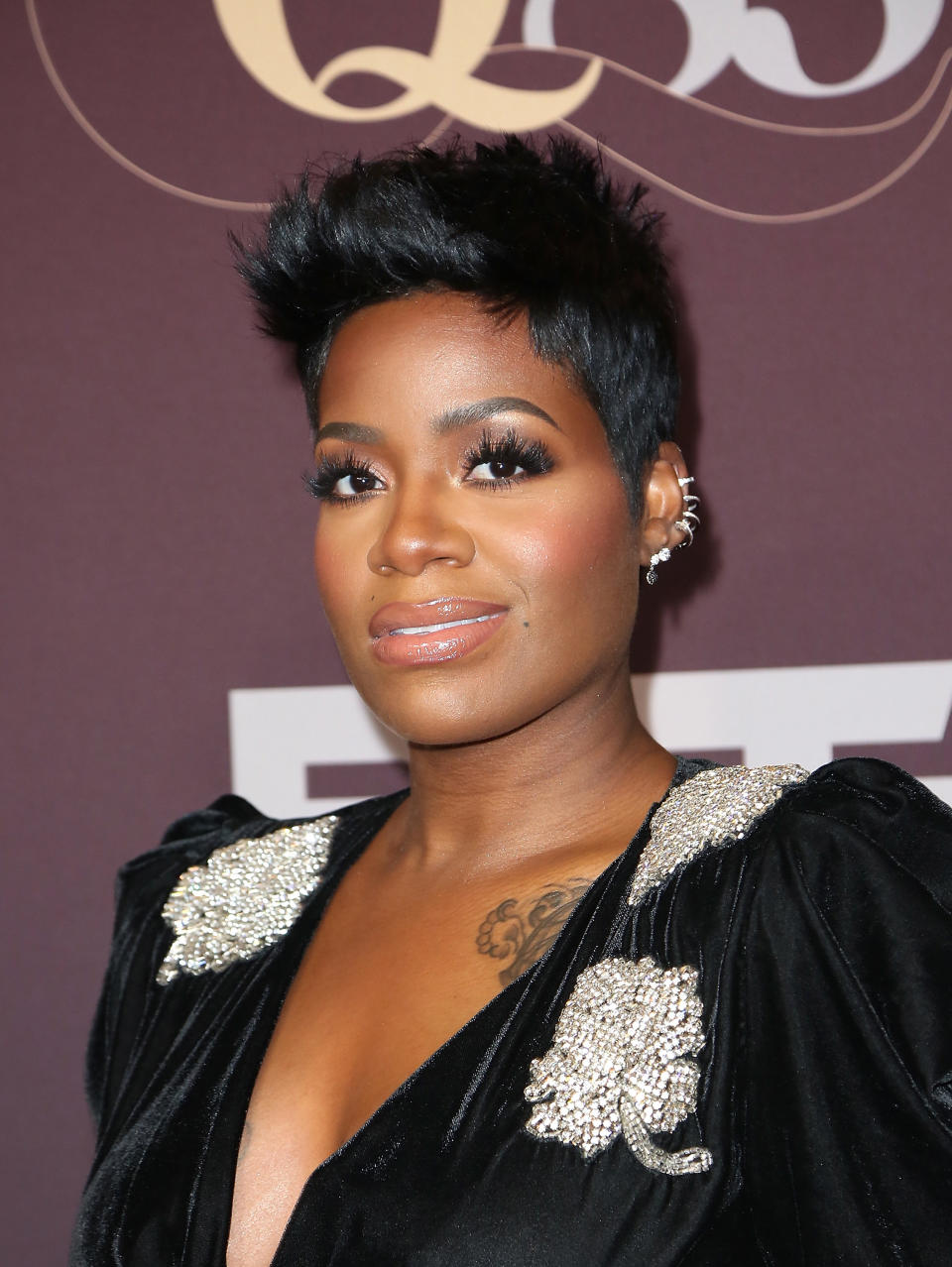 Fantasia in a spiky short haircut with multiple earrings