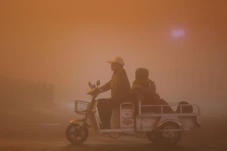 People ride during heavy smog in Lianyungang, Jiangsu province, China, November 13, 2016. REUTERS/Stringer