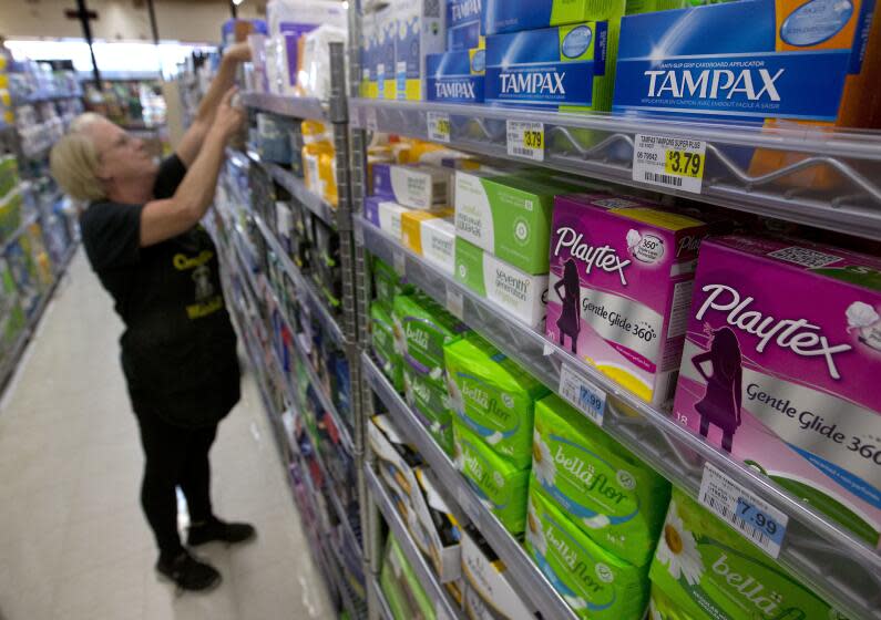 FILE - In this June 22, 2016 file photo, Tammy Compton restocks tampons at Compton's Market, in Sacramento, Calif. Bills to exempt feminine hygiene products and diapers from sales taxes were vetoed by Gov. Jerry Brown in 2016, but the measure's author's Assemblywomen Lorena Gonzalez Fletcher, D-San Diego, and Cristina Garcia, D-Bell Gardens, are reintroducing the proposals with a provision to fund their proposed sales tax exemptions with increased liquor taxes, Thursday, March 9, 2017. (AP Photo/Rich Pedroncelli, File)