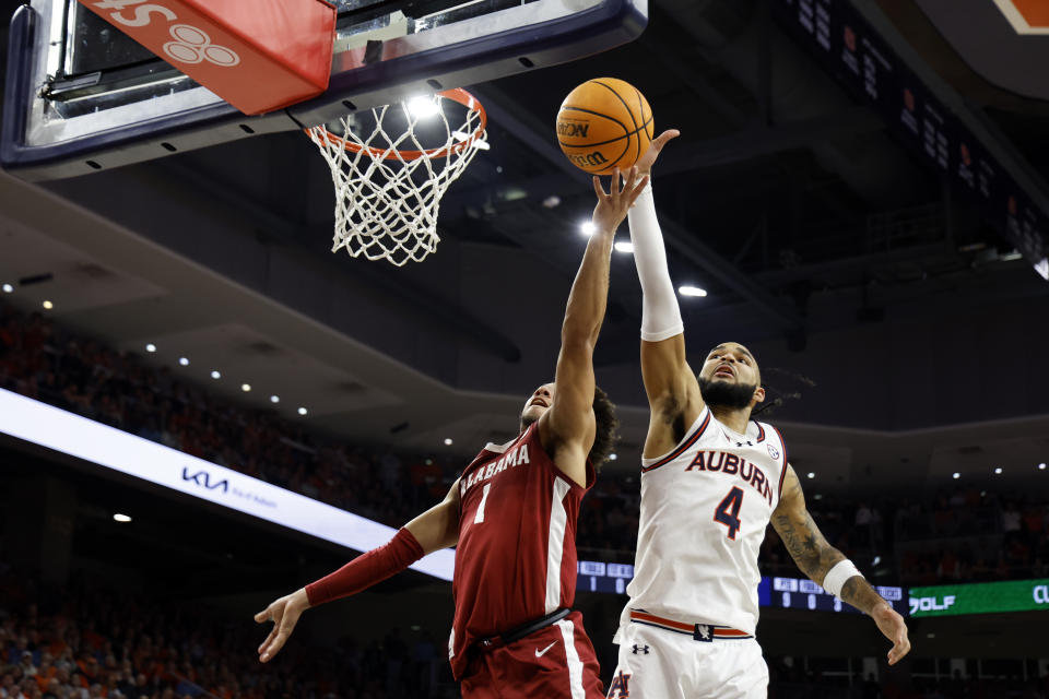 Auburn forward Johni Broome (4) blocks the shot of Alabama guard Mark Sears (1) during the first half of an NCAA college basketball game, Wednesday, Feb. 7, 2024, in Auburn, Ala. (AP Photo/Butch Dill)