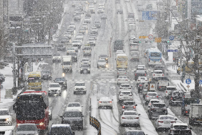 The vehicles drive in the snow in Suwon, South Korea, Thursday, Jan. 26, 2023. Cars slowed and stopped on icy roads and bundled-up commuters gingerly navigated snow-covered sidewalks as a snowstorm swept through the South Korean capital of Seoul and nearby regions on Thursday, extending a frigid cold spell that has the country in its grip. (Hong Ki-won/Yonhap via AP)