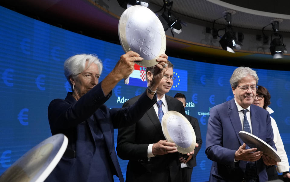 European Central Bank President Christine Lagarde, center, holds up a cardboard euro coin after a signing ceremony for Croatia to join the euro in Brussels, Tuesday, July 12, 2022. The European Union is set on Tuesday to remove the final obstacles for Croatia to adopt the euro, ensuring the first expansion of the currency bloc in almost a decade. (AP Photo/Virginia Mayo)