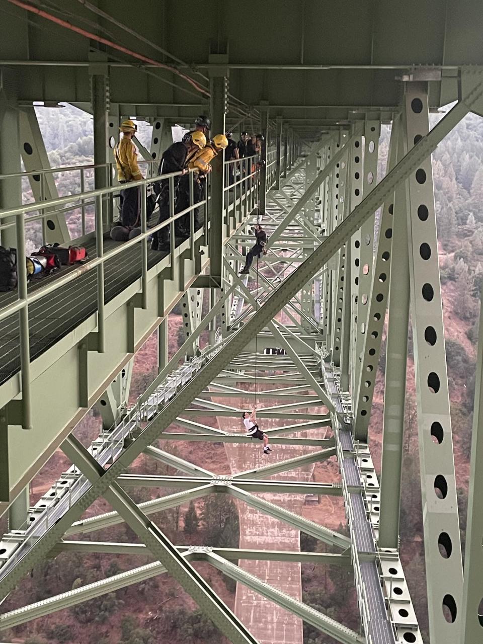 A rescuer is lowered down about 30 feet to where the 19-year-old dangles from the underside of the Foresthill Bridge on Monday, Sept. 18, 2023. / Credit: Placer County Sheriff's Office