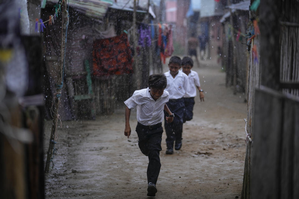 Los niños corren a la escuela bajo la lluvia en la isla Gardí Sugdub, parte del archipiélago de San Blas frente a la costa caribeña de Panamá, el lunes 27 de mayo de 2024. Debido al aumento del nivel del mar, unas 300 familias indígenas Guna se trasladarán a nuevas casas construidas por el gobierno, en tierra firme. (Foto AP/Matías Delacroix)