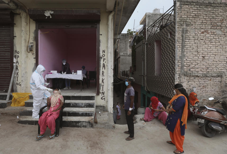 A health worker takes a nasal swab sample for COVID- 19 testing through rapid antigen methodology, in New Delhi, India , Friday, Aug. 7, 2020. As India hit another grim milestone in the coronavirus pandemic on Friday, crossing 2 million cases and more than 41,000 deaths, community health volunteers went on strike complaining they were ill-equipped to respond to the wave of infection in rural areas. (AP Photo/Manish Swarup)