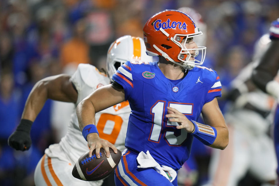 Florida quarterback Graham Mertz, right, scrambles as he looks for a receiver in front of Tennessee defensive lineman Tyler Baron, left, during the first half of an NCAA college football game, Saturday, Sept. 16, 2023, in Gainesville, Fla. (AP Photo/John Raoux)