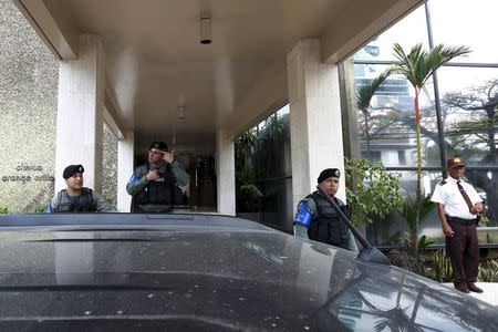 Police officers stand guard at the entrance of the Mossack Fonseca law firm office in Panama City April 12, 2016. REUTERS/Carlos Jasso