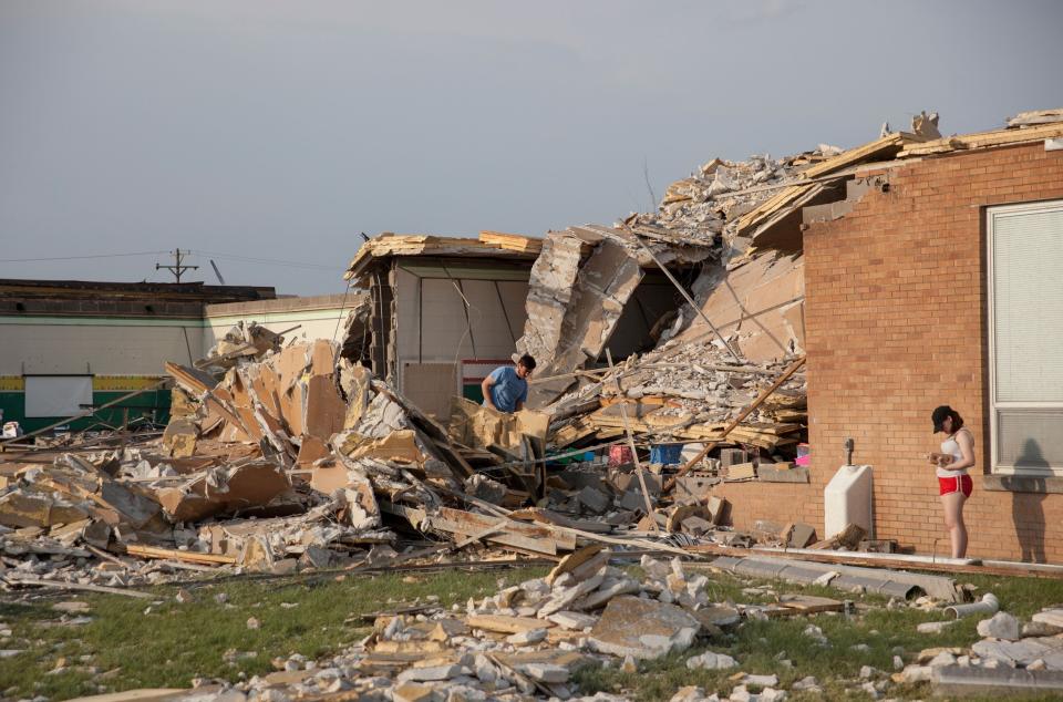 Damage at a school in Dayton, Ohio, is surveyed on Tuesday, after powerful tornadoes ripped through the area and caused at least one death. (Photo: SETH HERALD via Getty Images)