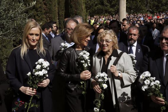 <p>La ministra de Defensa, María Dolores de Cospedal (c); la presidenta de la Comunidad de Madrid, Cristina Cifuentes (i), y la alcaldesa de la capital, Manuela Carmena, durante la ofrenda floral en el acto organizado por la AVT con motivo del decimotercer aniversario del 11M y del Día Europeo de las Víctimas del Terrorismo, este mediodía junto a los 191 cipreses y olivos que componen el Bosque del Recuerdo, en el parque del Retiro. Foto: EFE </p>