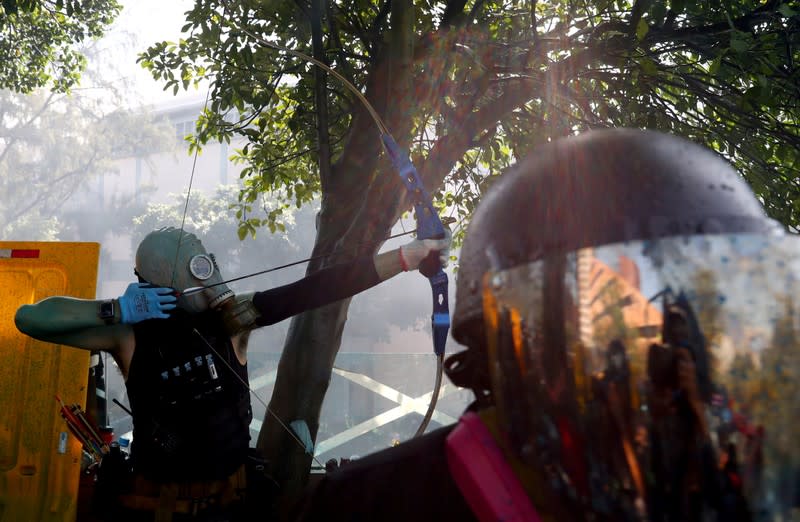 An anti-government protester uses a bow during clashes with police outside Hong Kong Polytechnic University