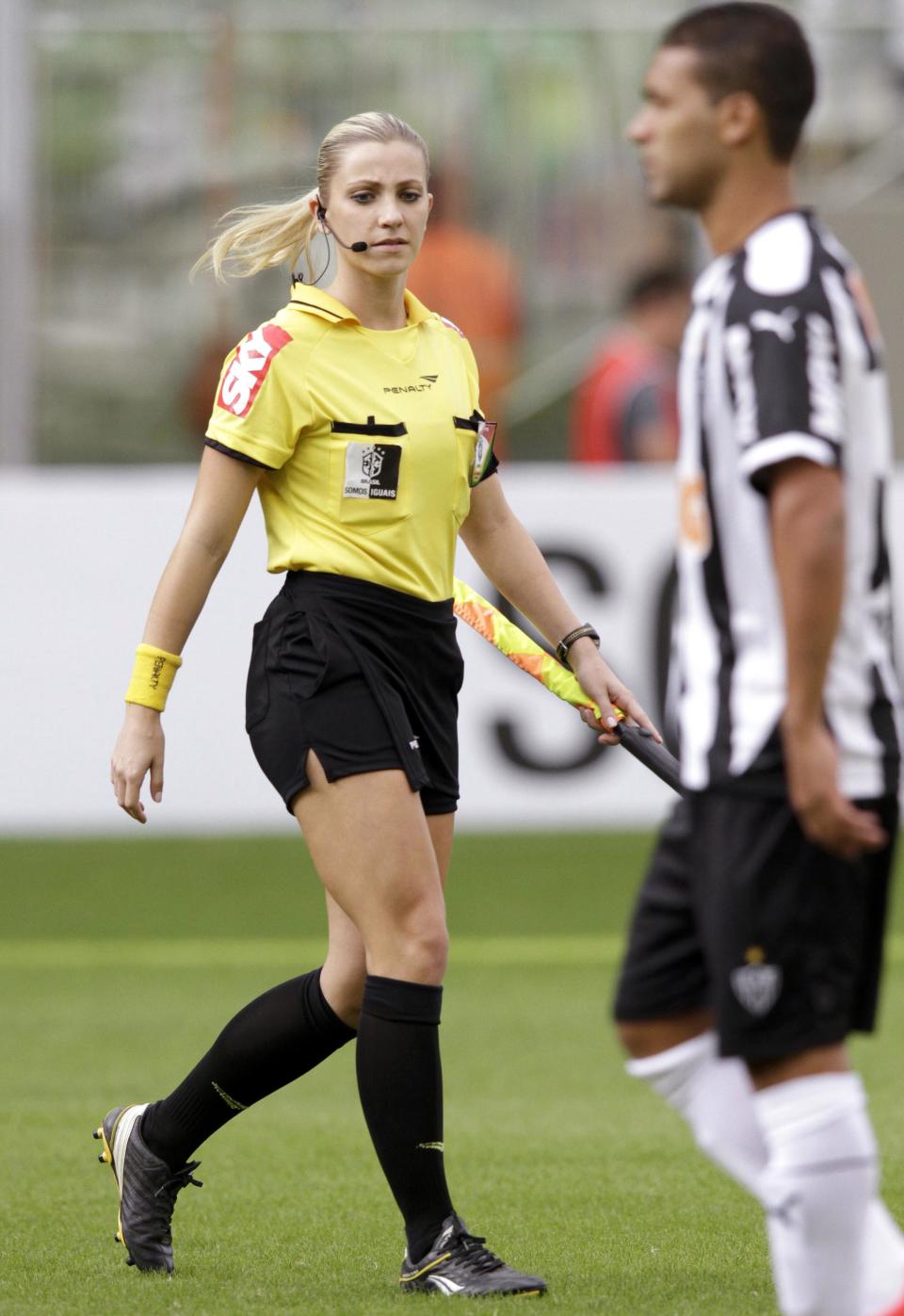 Brazil's referee assistant Fernanda Colombo Uliana walks next to an Atletico Mineiro player before the Brazilian championship soccer match between Atletico Mineiro and Cruzeiro in Belo Horizonte May 11, 2014. Uliana has just been granted FIFA official status by the refereeing committee of the Brazilian Football Confederation. REUTERS/Washington Alves (BRAZIL - Tags: SPORT SOCCER)