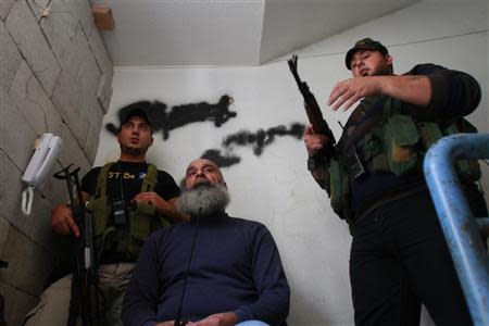 Sunni Muslim fighters stand with their weapons inside a building in Tripoli, northern Lebanon, November 30, 2013. REUTERS/Omar Ibrahim