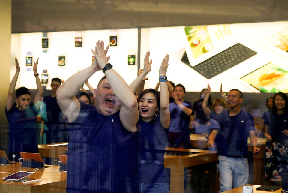 Staff members perform a dance routine before opening an Apple store to customers who line up to purchase the new iPhone 7 in Beijing, China, September 16, 2016. REUTERS/Thomas Peter