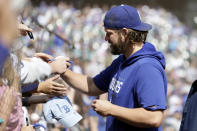 Los Angeles Dodgers starting pitcher Clayton Kershaw signs autographs before a baseball game against the Seattle Mariners, Sunday, Sept. 17, 2023, in Seattle. (AP Photo/John Froschauer)