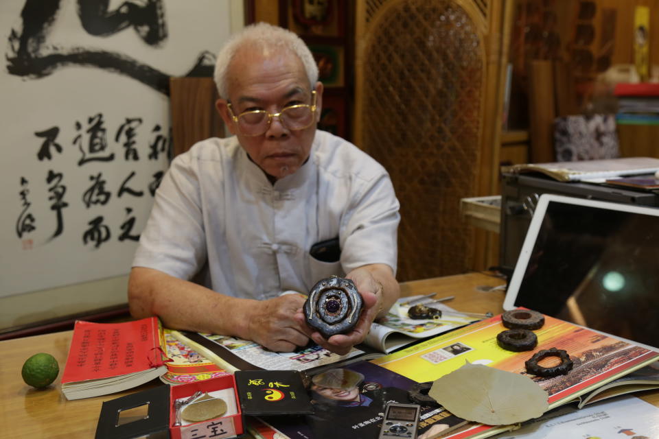 Chew holding a customised amulet that he wears every day. (PHOTO: Dhany Osman/Yahoo News Singapore)