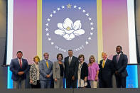 Members of the Mississippi State Flag Commission pose for a photo after a meeting, Wednesday, Sept. 2, 2020, at the Two Mississippi Museums in Jackson, Miss., during which they voted for the New Magnolia Flag as the choice to go on the November ballot to be voted upon to be the new state flag. During the meeting, the commission also voted the flag to now be known as the "In God We Trust Flag". (AP Photo/Rogelio V. Solis)