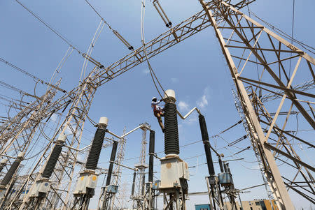 FILE PHOTO - A technician repairs power supply lines at a power plant at Mundra Port in the western Indian state of Gujarat April 2, 2014. REUTERS/Amit Dave/File Photo