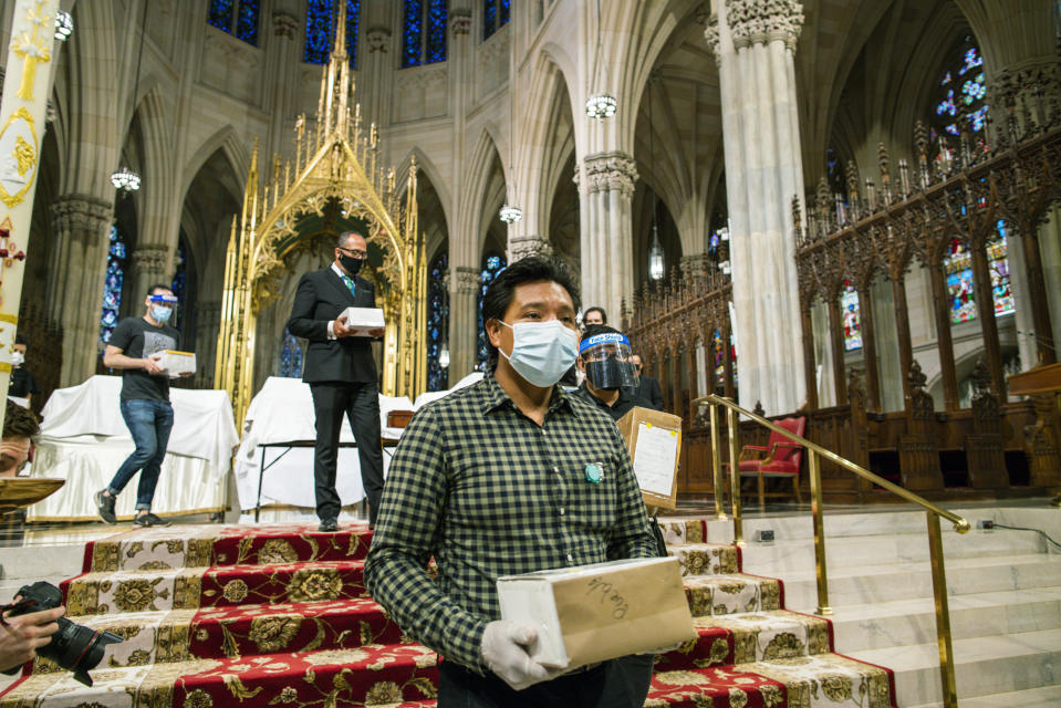 FILE - In this July 11, 2020, file photo, mourners carry the remains of loved ones following the blessing of the ashes of Mexicans who died from COVID-19 at St. Patrick's Cathedral in New York. The U.S. death toll from COVID-19 has topped 600,000, even as the vaccination drive has drastically slashed daily cases and deaths and allowed the country to emerge from the gloom. (AP Photo/Eduardo Munoz Alvarez, File)