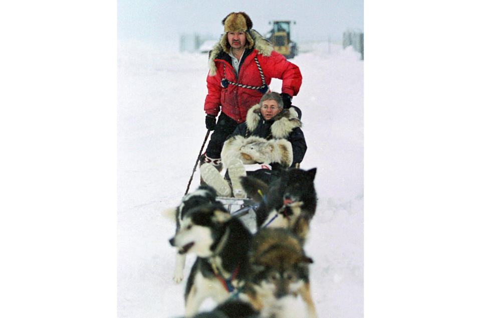 FILE - In this Jan. 19, 2000 file photo, U.S. Census Bureau director Kenneth Prewitt, seated, gets a dog sled ride into town by Harold Johnson after arriving for the first count in the Eskimo village of Unalakleet, Alaska. The 2020 Census kicks off Tuesday, Jan. 21, 2020, in a remote town of Alaska. To mark the occasion, The Associated Press is republishing an article from 20 years ago, when the census began in the village of Unalakleet. (AP Photo/Al Grillo, File)