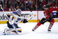 St. Louis Blues goaltender Jordan Binnington, left, makes a save on a shot against Chicago Blackhawks center Ryan Carpenter during the first period of an NHL hockey game in Chicago, Friday, Nov. 26, 2021. (AP Photo/Nam Y. Huh)