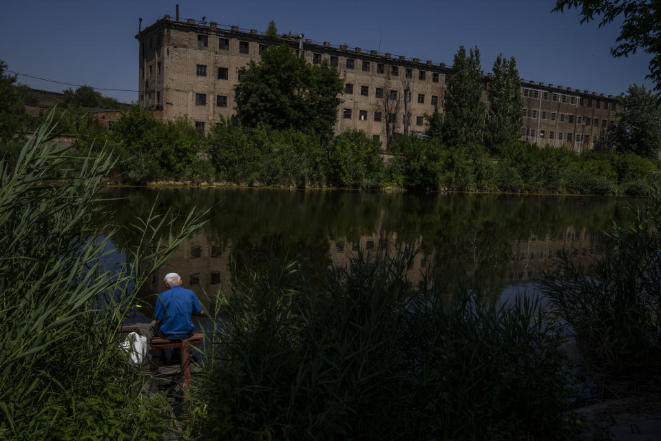 A fisherman resident who refuses to evacuate his hometown, fishes by the river, in Kramatorsk, eastern Ukraine, Wednesday, July 6, 2022. There are multiple reasons for residents' unwillingness to leave. Many are retirees, or from low-income families who fear they would not be able to support themselves financially away from home. Others are worried they would not be accepted in West Ukraine – a some concern based on a widely-perceived feeling that some Ukrainians resent predominantly Russian-speaking easterners and blame them for the war. A few, authorities say, also harbour pro-Russian sympathies and are waiting their arrival. Meanwhile, there are those who do not believe their lives simply would change under either the Russians or Ukrainians. (AP Photo/Nariman El-Mofty)