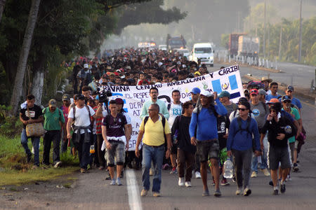 Migrants from Central America and Cuba walk on a highway during their journey towards the United States, in Tuzantan, Chiapas state, Mexico March 25, 2019. REUTERS/Jose Torres