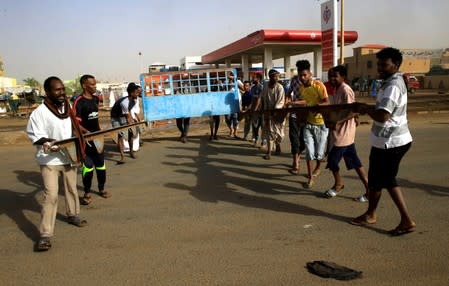 FILE PHOTO: Sudanese protesters erect a barricade on a street and demanding that the country's Transitional Military Council hand over power to civilians in Khartoum