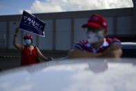 Supporters of President Donald Trump gather moments before leaving for the headquarters of the Republican party in support of his candidacy a few weeks before the presidential election next November, in Carolina, Puerto Rico, Sunday, Oct. 18, 2020. President Donald Trump and former Vice President Joe Biden are targeting Puerto Rico in a way never seen before to gather the attention of tens of thousands of potential voters in the battleground state of Florida. (AP Photo/Carlos Giusti)