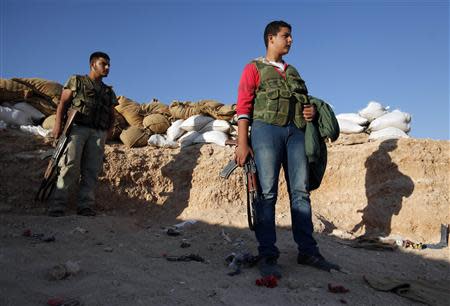 Free Syrian Army fighters stand with their weapons in a trench where sandbags are piled near the Kwers military airport, where forces loyal to Syria's President Bashar al-Assad are based, in Aleppo September 9, 2013. REUTERS/Loubna Mrie