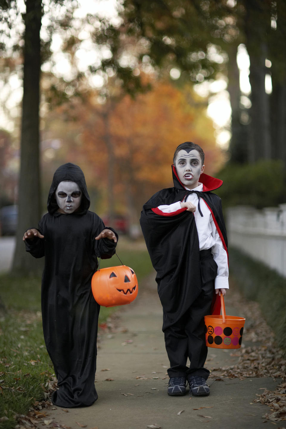 Two boys (6-7) wearing Halloween costume on sidewalk, portrait (Christopher Robbins / Getty Images)