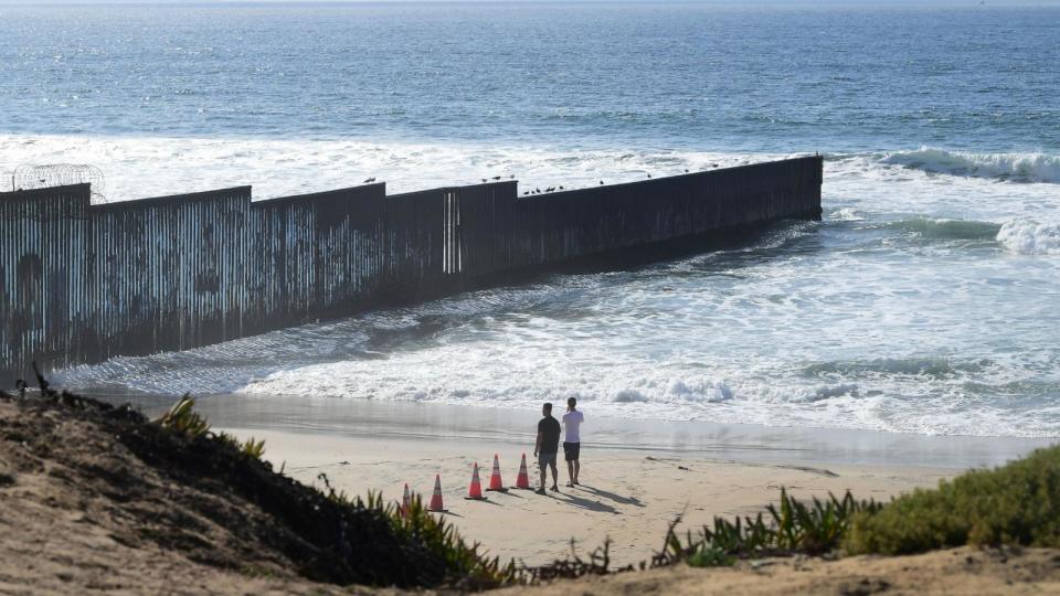 PHOTO: People look towards the US-Mexico border fence that runs into the Pacific Ocean, seen from Imperial Beach outside San Diego, Nov. 7, 2021. (Frederic J. Brown/AFP via Getty Images)