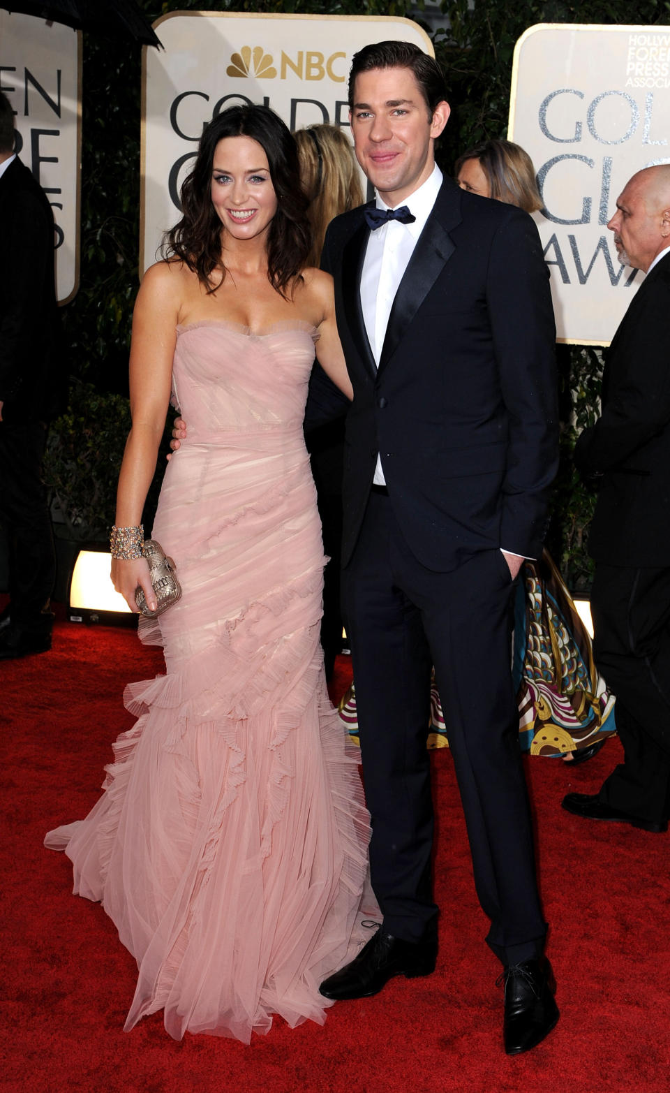 Actors Emily Blunt poses in a pink Dolce & Gabbana gown with John Krasinski at the 2010 Golden Globe Awards. (Image via Getty Images)