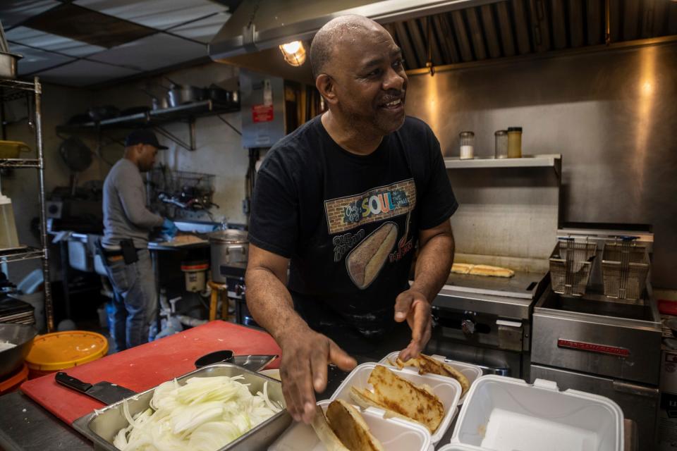 Greg Beard, 62, chef and owner of Soul-N-The Wall, prepares an order of Boogaloo sandwiches for Detroit Fire Department members inside the restaurant's kitchen in Detroit on Wednesday, June 21, 2023.