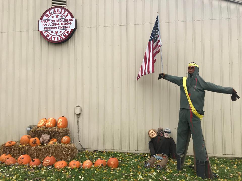 A scarecrow is displayed outside Quality Coatings in Fowlerville, Mich., on Sunday, after the owner received complaints and made some changes.