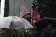 People walk in front of an electronic stock board showing Japan's Nikkei index at a securities firm, Wednesday, Oct. 9, 2024, in Tokyo. (AP Photo/Eugene Hoshiko)