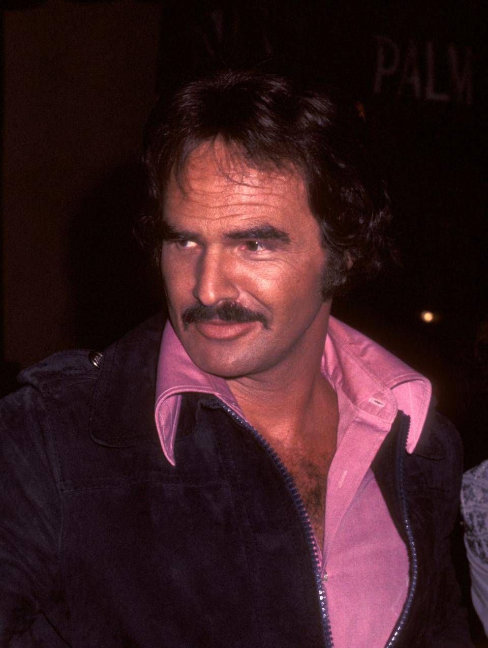 <p>Reynolds dons a devil-may-care pink shirt at the Palm restaurant in Beverly Hills in April 1977.</p>