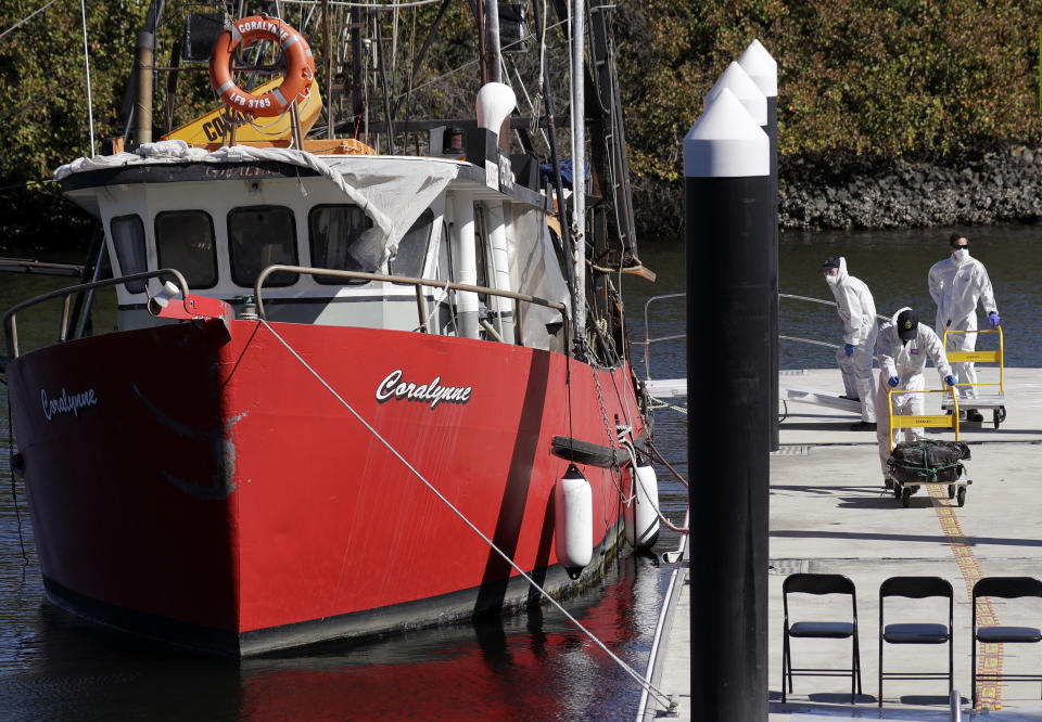 Investigators unload materials believed to be cocaine from Coralynne, an Australian trawler, in Sydney, Tuesday, Aug. 18, 2020. Australian authorities said Tuesday they seized a large quantity of cocaine from the fishing boat in treacherous seas off the east coast. (AP Photo/Rick Rycroft)