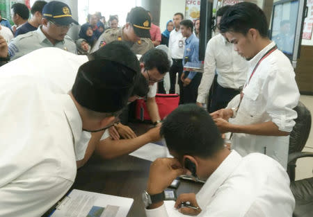 Lion Air officials check the passenger list of Lion Air flight JT610 that crashed into the sea, at Depati Amir airport in Pangkal Pinang, Indonesia, October 29, 2018. Antara Foto/Elza Elvia via REUTERS