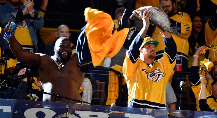 A member of the Tennessee Titans holds up a catfish to pump up the Nashville Predators crowd before Game 3 of the Western Conference final. (Christopher Hanewinckel-USA TODAY Sports)