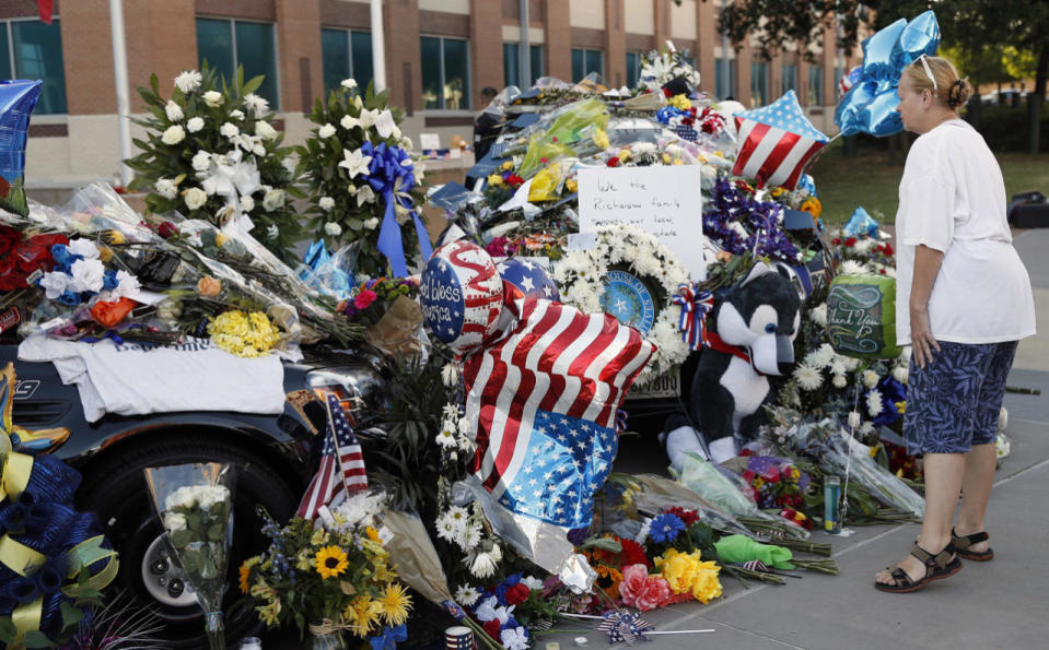 Mary Savage visits a make-shift memorial in front of the Dallas police department