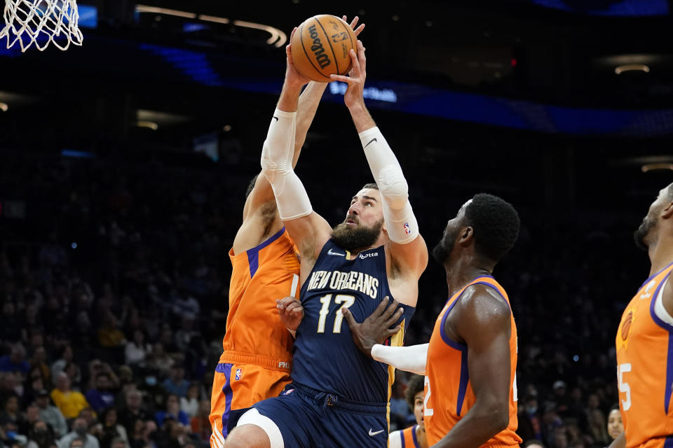 New Orleans Pelicans center Jonas Valanciunas (17) shoots as Phoenix Suns center Deandre Ayton, right, looks on during the first half of an NBA basketball game, Friday, Feb. 25, 2022, in Phoenix. (AP Photo/Matt York)