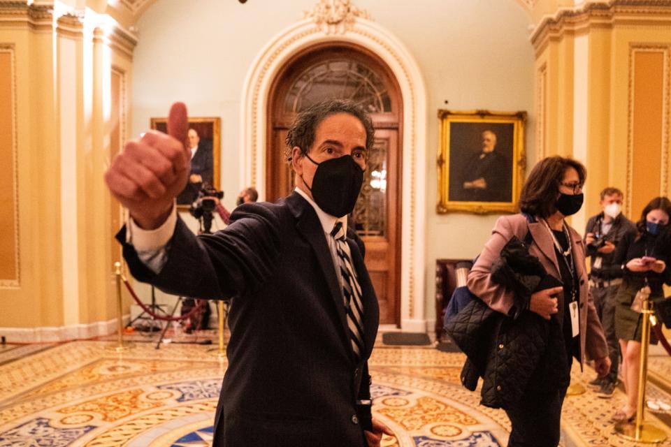 Rep. Jamie Raskin gestures to National Guard troops as he walks in.