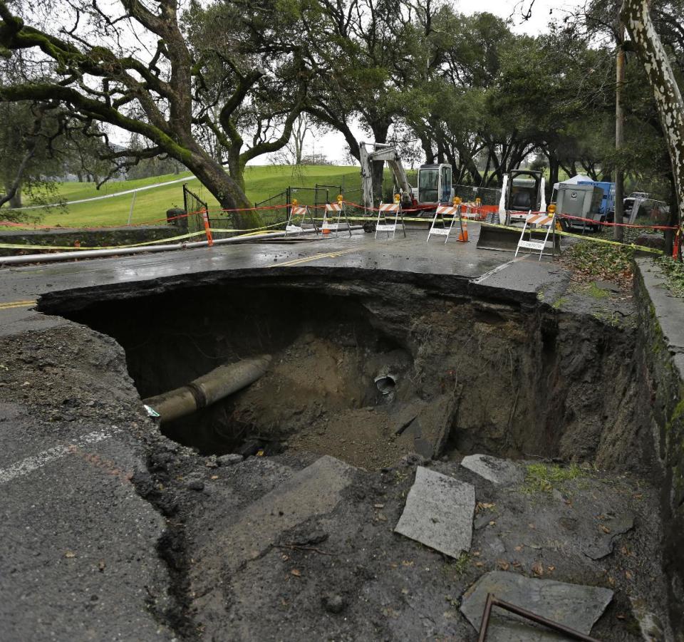 A 72-inch deep sinkhole is seen Wednesday, Jan. 18, 2017, in Orinda, Calif. The city council of Orinda declared a State of Emergency Tuesday night because of a large sinkhole caused by last week's wet weather, which ruptured two sewer lines. Repairs will take at least four weeks, as the San Francisco Bay Area is being hit with a new series of rain storms. (AP Photo/Ben Margot)