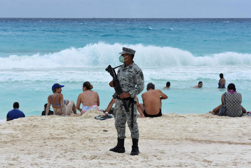 A member of the newly created Tourist Security Battalion of the National Guard stands guard at a beach in Cancun, Quintana Roo State, Mexico, on Dec. 2, 2021.